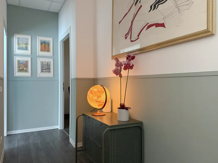 Corridoio dello studio con mappamondo illuminato e orchidea